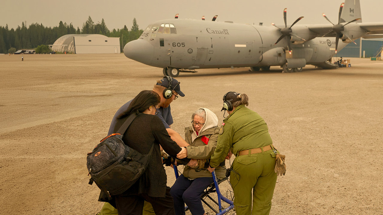 Norway House, M.B. – Members of the Royal Canadian Air Force help evacuate Abbie Duskun (seated) and her daughter Veronica Clarke as they board an aircraft on June 3, 2025. (Photo by David Lipnowski / The Canadian Press via AP)